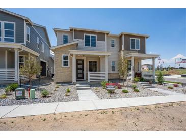 Charming two-story home with stone accents, inviting front porch, and well-manicured landscaping at 1366 Penner Dr, Erie, CO 80026