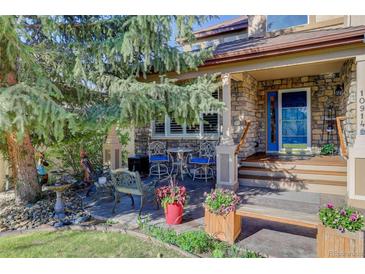 Inviting stone front porch with outdoor seating and well-maintained landscaping at 10914 W Coco Pl, Littleton, CO 80127