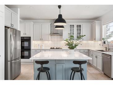Modern kitchen features a large island with a marble countertop and stainless steel appliances at 25362 E Indore Dr, Aurora, CO 80016
