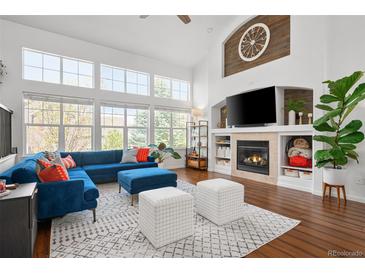 Bright living room with large windows, fireplace, and comfortable seating at 25362 E Indore Dr, Aurora, CO 80016