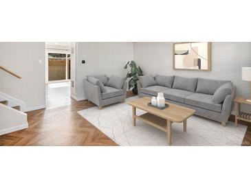Bright living room with wood floors, gray sofa and chair, art, and a decorative coffee table at 9272 E Mansfield Ave, Denver, CO 80237