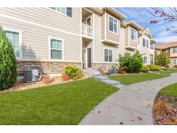 Tan three-story townhome with landscaping and walkway at 1536 Sepia Ave, Longmont, CO 80501