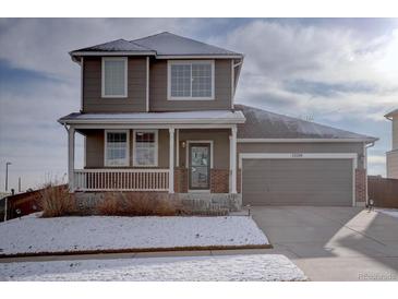 Charming two-story home featuring a covered front porch and an attached two-car garage at 12218 S Oak Bluff Trl, Parker, CO 80134