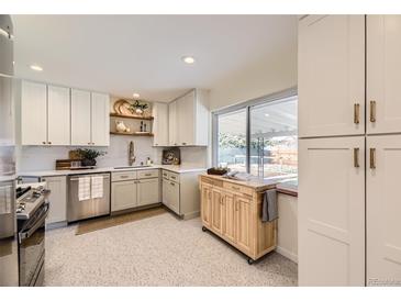 Bright kitchen featuring white cabinets, stainless steel appliances, and a butcher block island at 2822 S Zenobia St, Denver, CO 80236