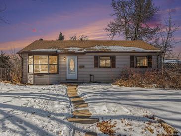 Tan one-story house with snow covered yard, evening photo at 5191 S Pennsylvania St, Littleton, CO 80121