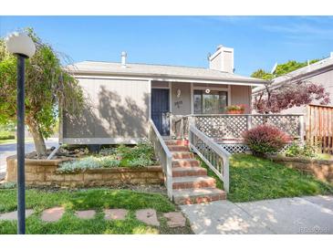 Inviting home featuring a well-maintained front yard, brick stairs, and a charming covered porch at 3853 S Genoa Ct # D, Aurora, CO 80013