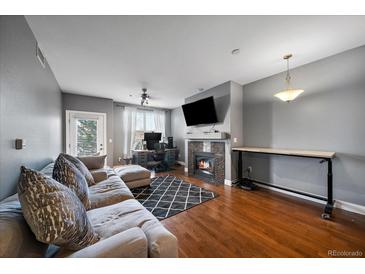 Spacious living room with fireplace, hardwood floors, and access to a private balcony at 9059 E Panorama Cir # B306, Englewood, CO 80112