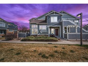 Charming townhome with well-maintained front yard and inviting entry; beautiful sunset sky at 14300 Waterside Ln # J4, Broomfield, CO 80023