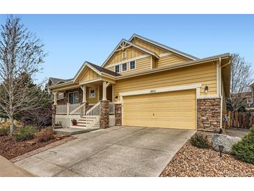 Inviting two-story home featuring a covered front porch, stone accents, and a two-car garage at 2872 Dreamcatcher Loop, Castle Rock, CO 80109
