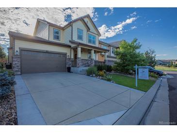 Charming two-story home with a well-manicured lawn and inviting front porch; For Sale sign in the yard at 651 Tiger Lily Way, Highlands Ranch, CO 80126