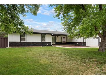 Charming home featuring a well-manicured lawn, stone accents, and mature trees at 8595 S Yarrow St, Littleton, CO 80128