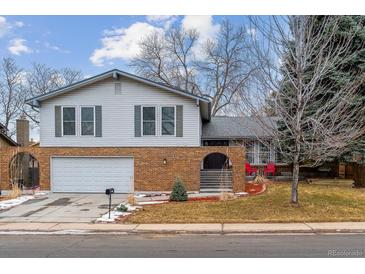 Charming two-story home with a brick facade, attached garage, and inviting front entrance at 7484 E Mercer Pl, Denver, CO 80237