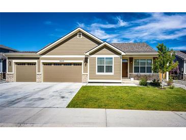Charming single-story home featuring a spacious two car garage and well-manicured front lawn at 56459 E 23Rd Pl, Strasburg, CO 80136