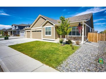 Charming home featuring well-manicured lawn and a quaint front porch area perfect for enjoying the outdoors at 56459 E 23Rd Pl, Strasburg, CO 80136