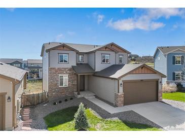 Two-story home featuring a stone facade, well-manicured lawn, and an attached two-car garage at 1018 Mcmurdo Cir, Castle Rock, CO 80108