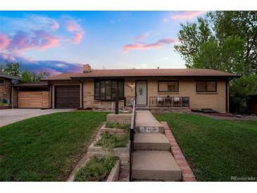 Charming brick home with a well-manicured lawn, updated siding, and cozy front porch seating at 2840 S Yates St, Denver, CO 80236