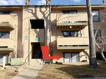 A three-story condo building with private balconies, and a walking path leading to the front door at 390 Zang St # 5-102, Lakewood, CO 80228