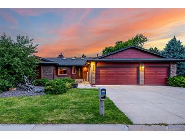 Charming single-Gathering home featuring a well-maintained lawn, a brick facade, and a spacious two-car garage at 8696 W Iliff Ave, Lakewood, CO 80227