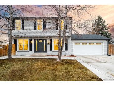 Two-story house with gray exterior, white garage, and landscaped lawn at 5181 S Quintero St, Centennial, CO 80015