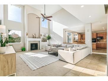 Bright living room featuring a fireplace, soaring ceilings, and a seamless open-concept design at 3532 Springbriar Dr, Castle Rock, CO 80109