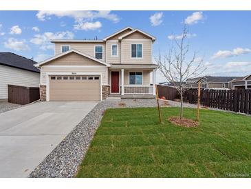 Inviting two-story home with a well-manicured lawn and a charming front porch; the perfect place to welcome guests at 9652 Cathay St, Commerce City, CO 80022