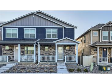 Charming townhome with stone accents, a covered porch, and tidy landscaping at 7024 Kali Ct, Frederick, CO 80530