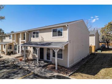 Inviting exterior of a tan-colored townhome featuring a covered porch and well-maintained landscaping at 8915 Field St # 113, Westminster, CO 80021