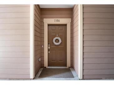 Inviting brown front door with a decorative wreath and unit number 106 at 10056 W Unser Dr # 106, Littleton, CO 80127