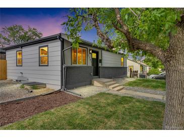 Charming single-story home with a well-maintained lawn, gray paint, and lovely landscaping at 2701 Barnhart St, Thornton, CO 80229