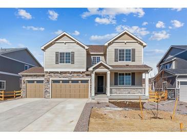 Charming two-story home featuring a three-car garage, stone accents, and a welcoming front porch at 25041 E 38Th Ave, Aurora, CO 80019