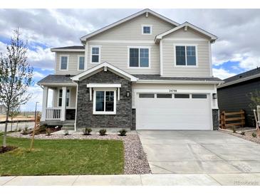 Beautiful two-story home featuring stone accents, a two-car garage, and manicured landscaping at 24798 E 40Th Ave, Aurora, CO 80019