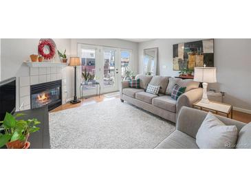 Cozy living room features a fireplace, plush seating, and access to an outdoor deck at 5252 W 68Th Ave, Arvada, CO 80003