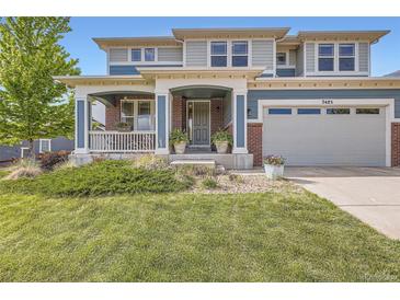 Charming two-story home featuring a welcoming front porch, lush green lawn, and attached two-car garage at 7485 S Jackson Gap Way, Aurora, CO 80016