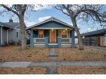 Charming blue home with a welcoming front porch and a delightful pink front door at 1560 Clinton St, Aurora, CO 80010