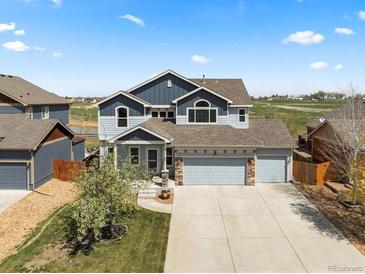 Charming two-story home boasts a manicured lawn and an attached two-car garage at 2757 Stallion Way, Mead, CO 80542