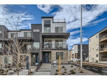 Modern townhome with brick facade, dual balconies, and a rooftop patio at 1751 Peak Loop, Broomfield, CO 80023