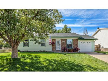 Brick ranch home with a green trimmed roof, attached garage, and well-maintained lawn at 16598 E Lasalle Pl, Aurora, CO 80013