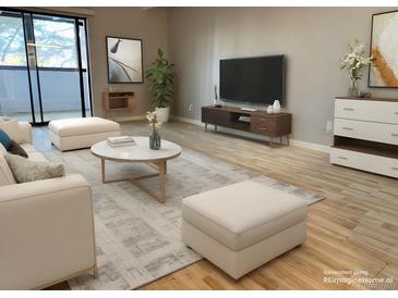 Bright living room featuring stylish furniture, modern decor, and a sliding door for natural light at 1011 S Ironton St # 107, Aurora, CO 80012