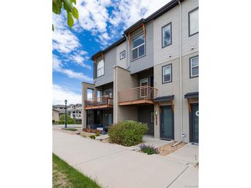 Modern townhome with multiple stories, gray and white exterior, and inviting balcony space at 10154 Belvedere Loop, Lone Tree, CO 80124
