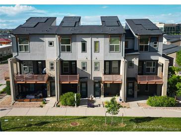 Modern townhomes showcasing solar panels, balconies, landscaped grounds, and covered outdoor seating areas at 10154 Belvedere Loop, Lone Tree, CO 80124