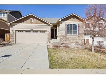 Charming home featuring a two-car garage, stone accents, and a well-maintained lawn at 24437 E Powers Ave, Aurora, CO 80016