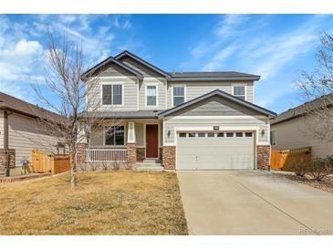 Charming two-story home featuring a well-maintained lawn, stone accents, and an attached two-car garage at 3310 Quicksilver Rd, Frederick, CO 80516