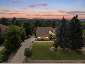 Lovely aerial view of home with mature landscaping, a long drive, and mountain views at sunset at 1025 S Butler Way, Lakewood, CO 80226