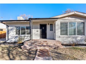 Charming brick home with a well-maintained front yard, inviting entrance, and large windows at 2230 Jamaica St, Aurora, CO 80010