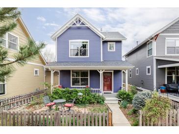 Charming blue two-story home with a cozy front yard and inviting red front door at 9124 E 29Th Pl, Denver, CO 80238