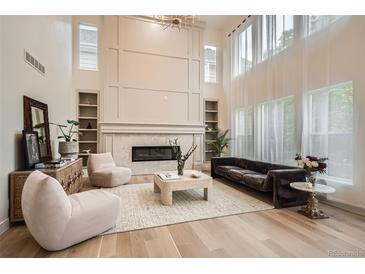 Bright living room with floor-to-ceiling fireplace, hardwood floors, and clerestory windows at 22367 Quail Run Dr, Parker, CO 80138