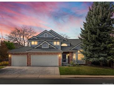 Charming two-story home with a well-manicured lawn and three car garage at sunset at 1792 W Kettle Ave, Littleton, CO 80120