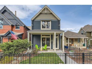 Charming two-story home with a quaint front porch and green chairs, set behind a black metal fence at 35 Elati St, Denver, CO 80223