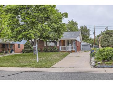Charming brick home featuring a well-manicured lawn, covered porch, and spacious driveway at 1824 S Columbine St, Denver, CO 80210