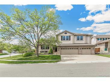 Charming two-story home featuring a three-car garage, landscaped yard, and a beautiful mature tree at 5789 S Jay St, Littleton, CO 80123